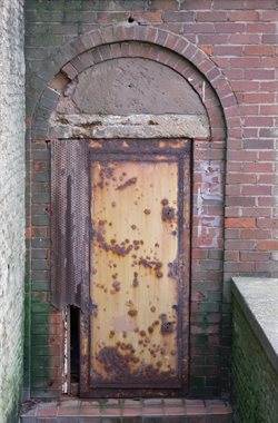Badly rusting doors to disused toilets under promenade lift entrance