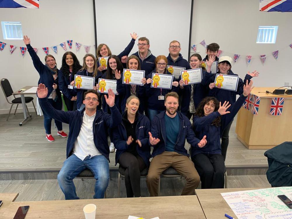 Group of people sat and stood raising arms in celebration.