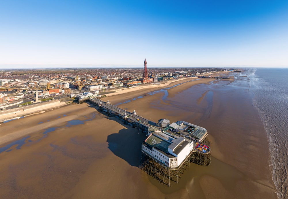 Aerial view of pier, beach and promenade.