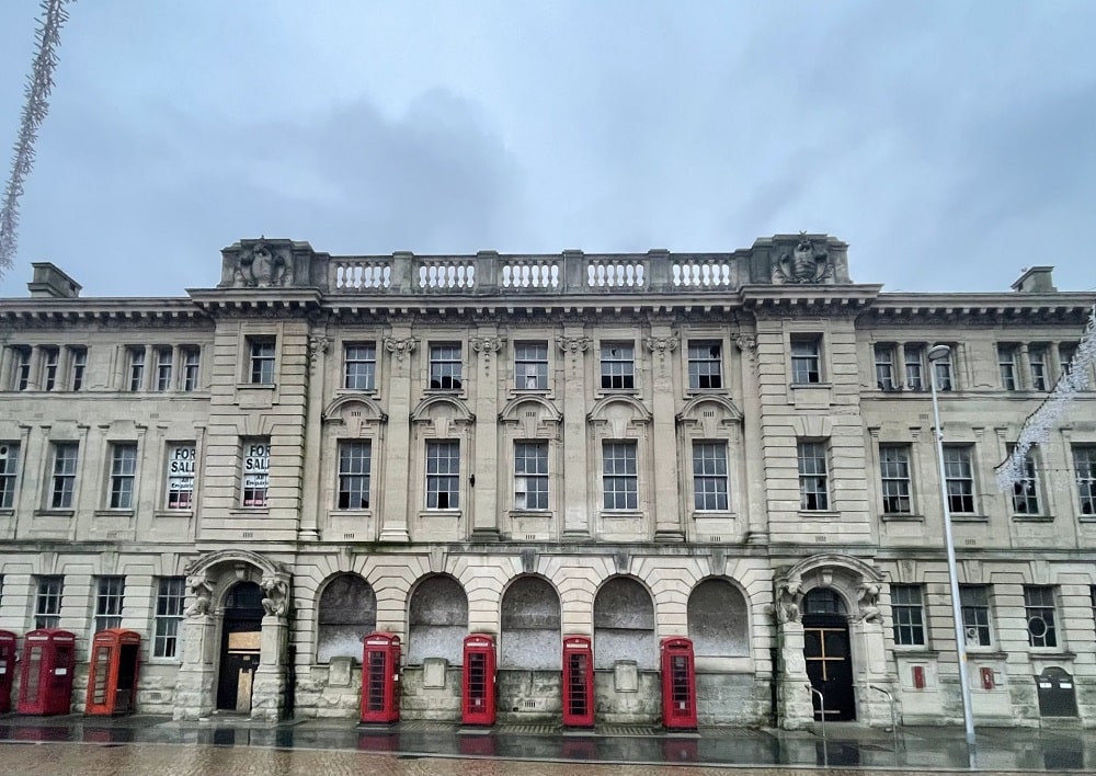 Boarded up dilapidated ornate building.