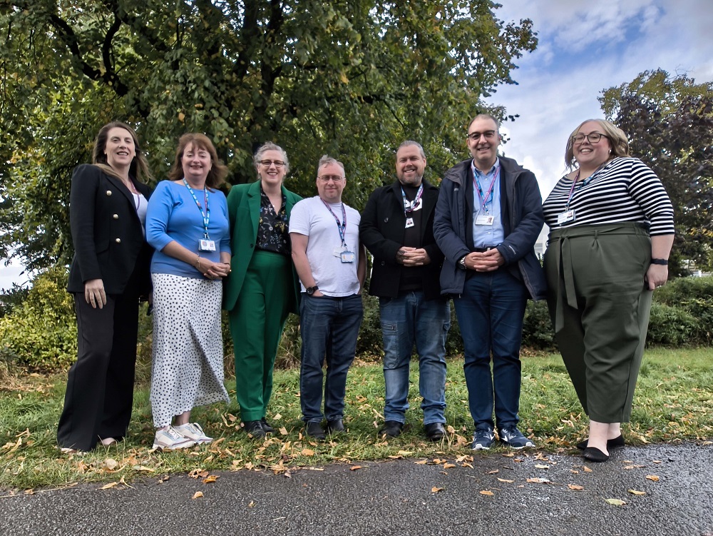 The IPS Central and West Lancashire team outside with grass, trees and bushes in the background