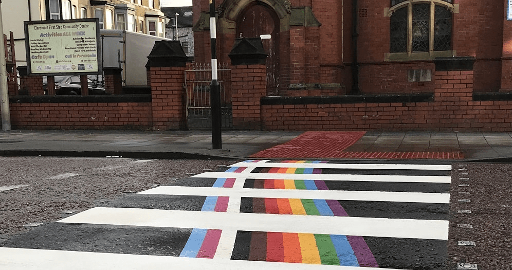 Zebra crossing featuring a rainbow pride flag.