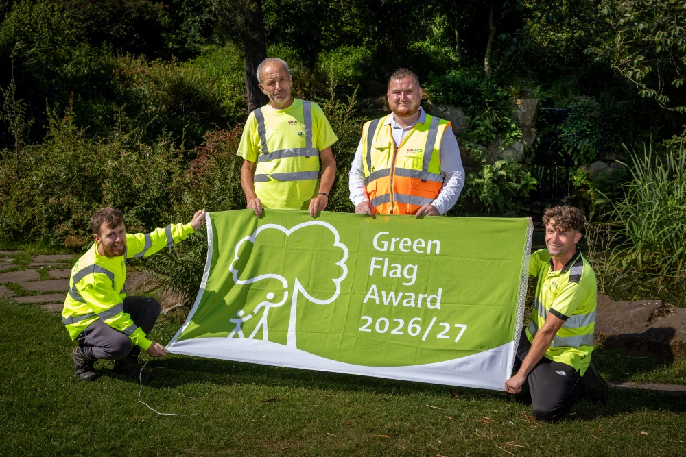 Four people holding the green flag award 