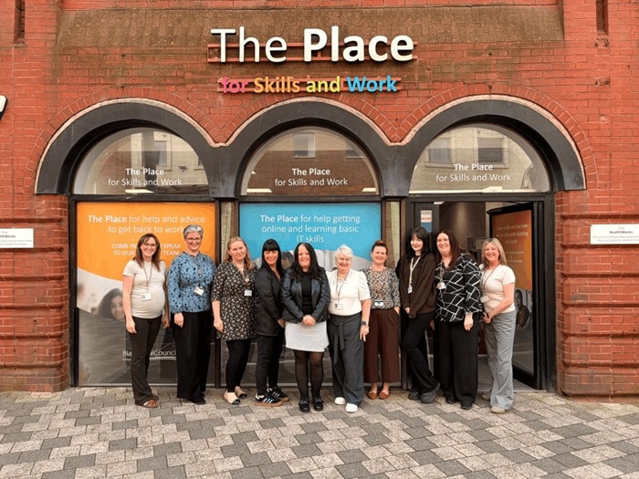 Group of people stood in front of office building.