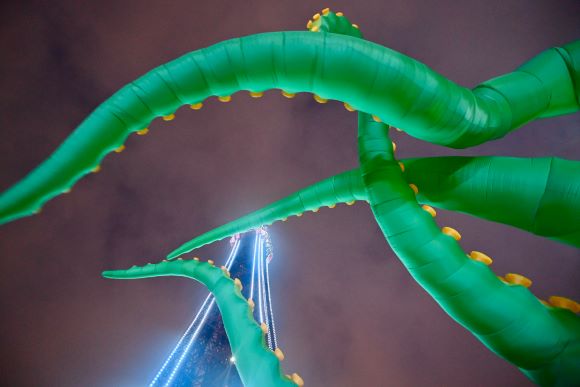Inflatable green tentacles with yellow spots in front of Blackpool Tower  