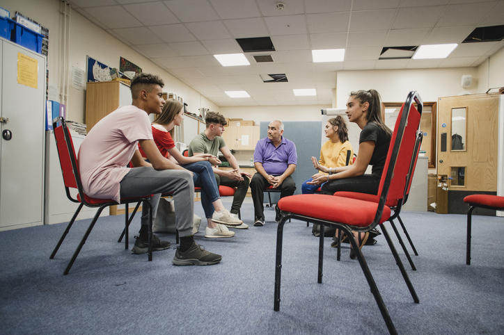 A stock image of young people and a youth worker