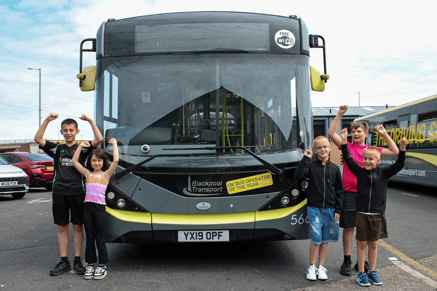A group of children standing next to a bus 