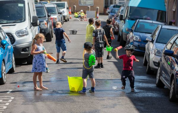 Group of kids having water fight on a street 