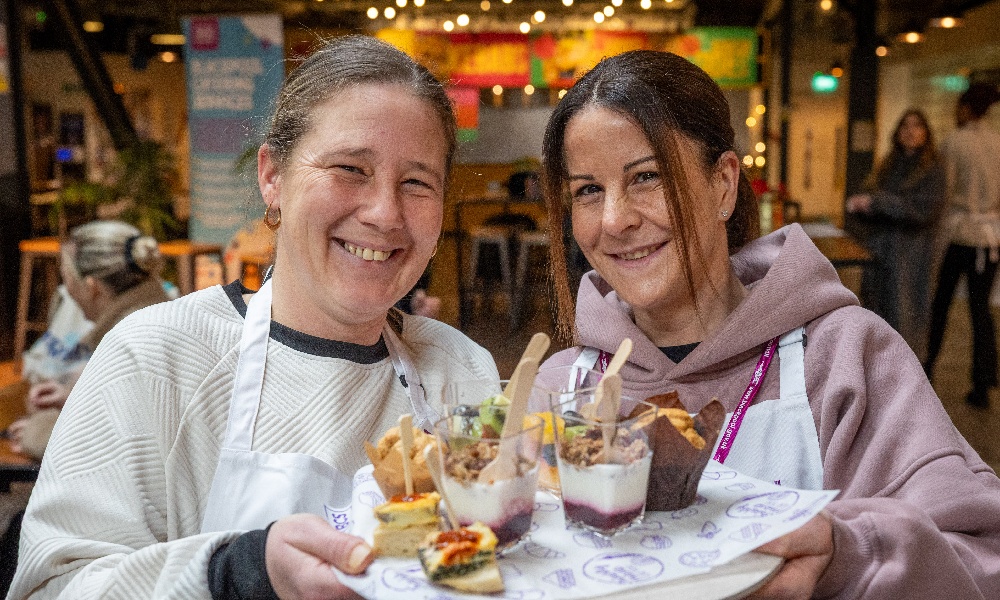 Two women from Blackpool Council's School Catering Services hold up samples of the colourful and healthy new dishes now being served to schoolchildren