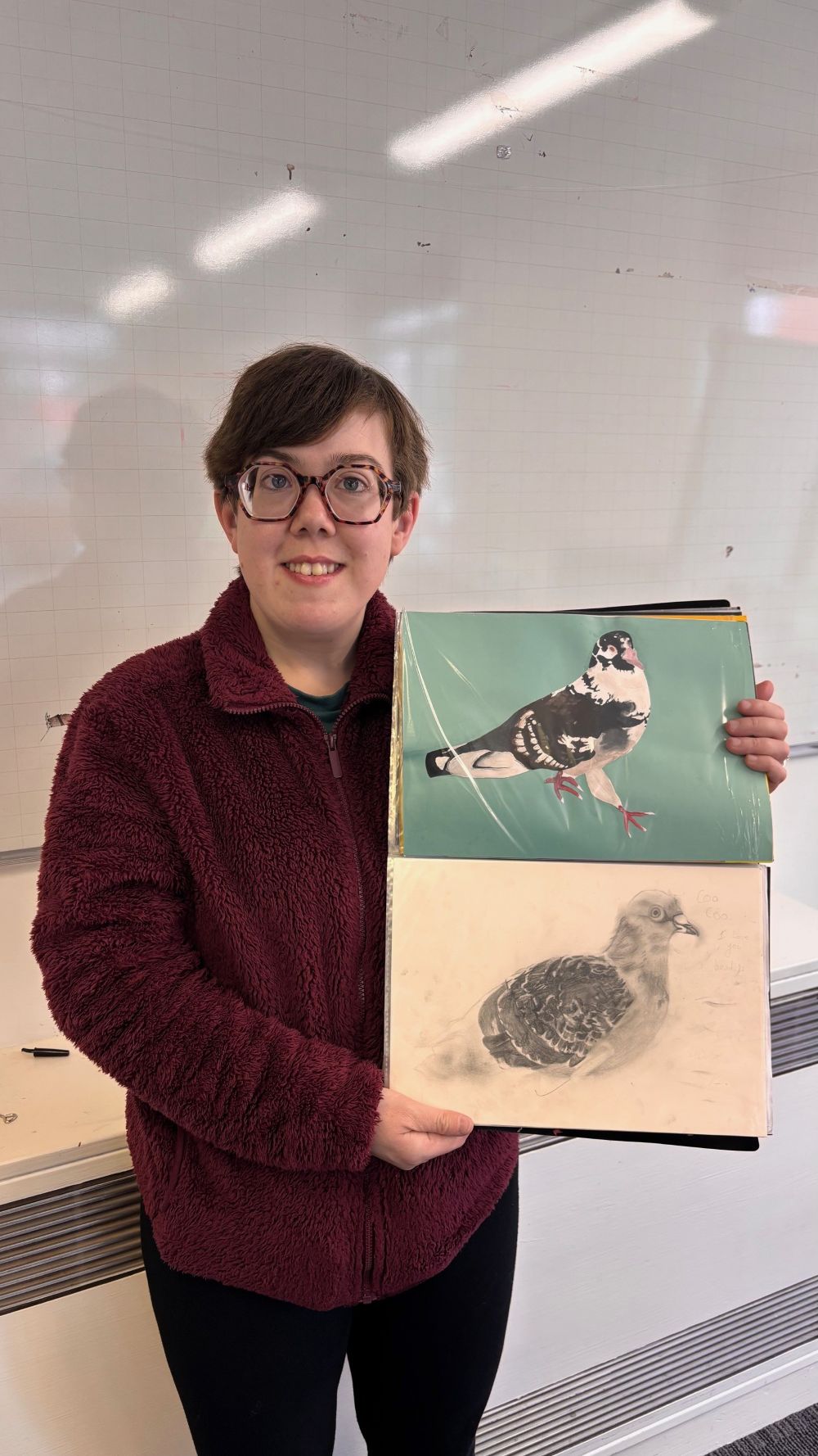 Artist Kylie showing her paintings and drawings of pigeons