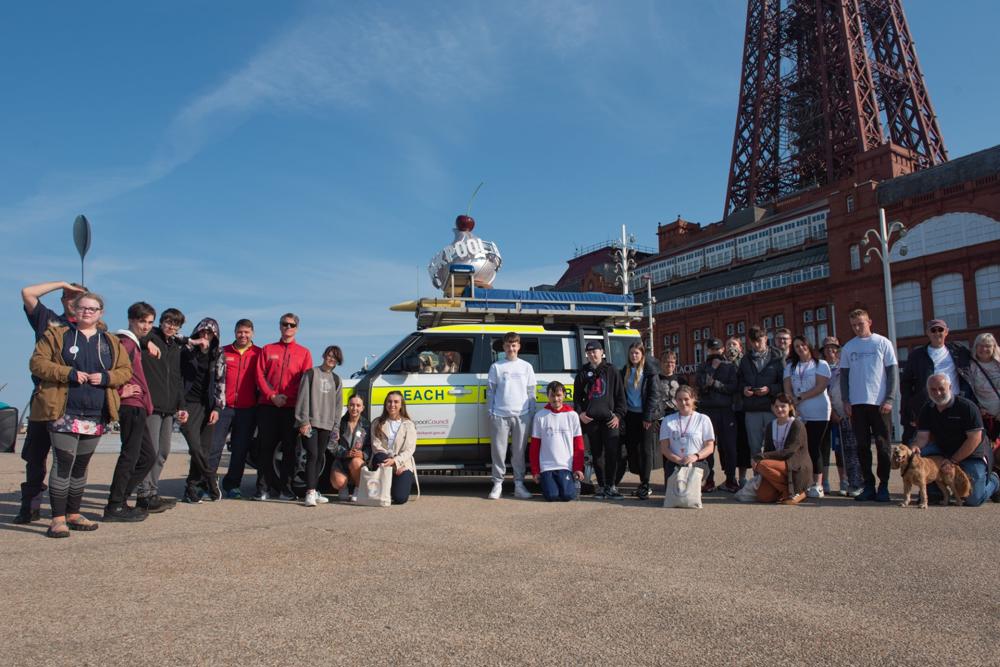 Young people taking part in a walk for International Peace Day stood in front of Blackpool Tower.
