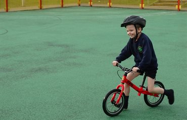 Young boy smiling on a balance bike