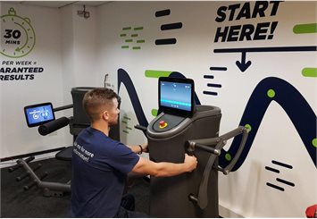 Member of staff using the express fitness equipment