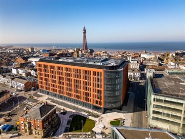 An aerial photograph of an office building with Blackpool Tower in the background