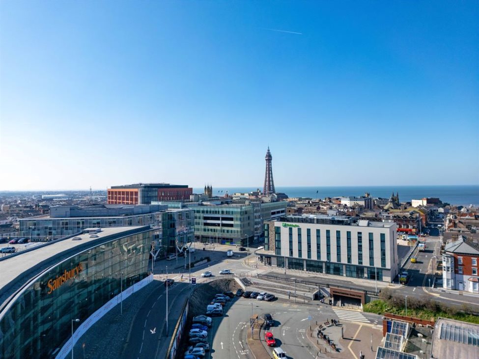 An aerial photograph of a business district with Blackpool Tower in the background