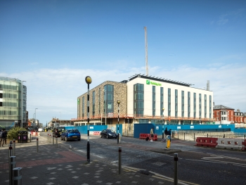 Image of a hotel development with road and zebra crossing in the foreground