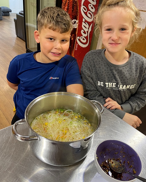 Children with a pan of pasta