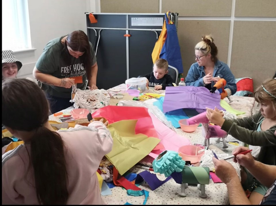 Adults and children around a table playing