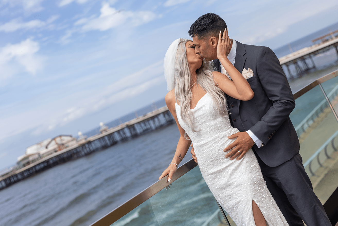 Newly married couple kissing on the promenade.