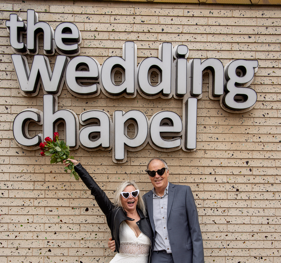 couple stood in front of wedding chapel sign