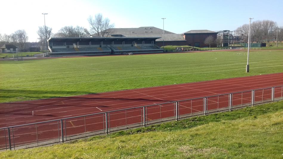 Outdoor athletics track and spectators stand.