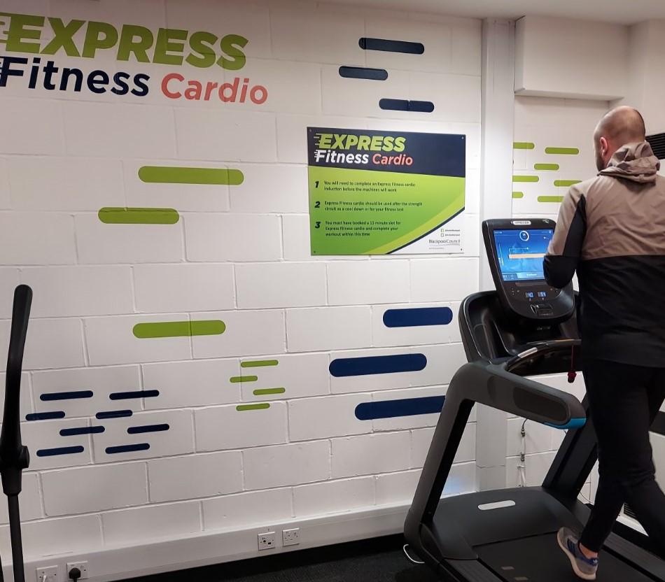Express Fitness cardio machine with a man running on the machine