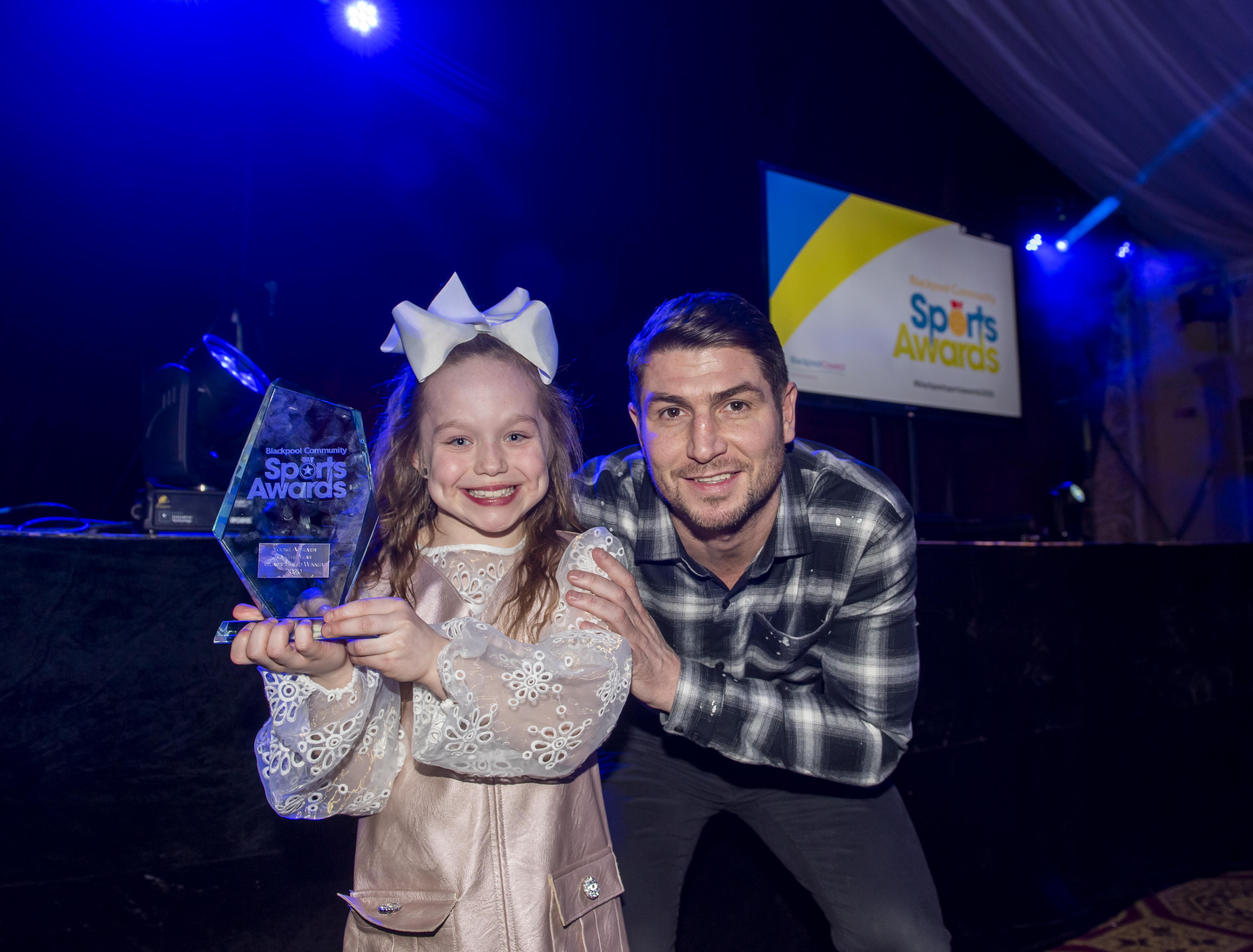 A man and a girl holding their award