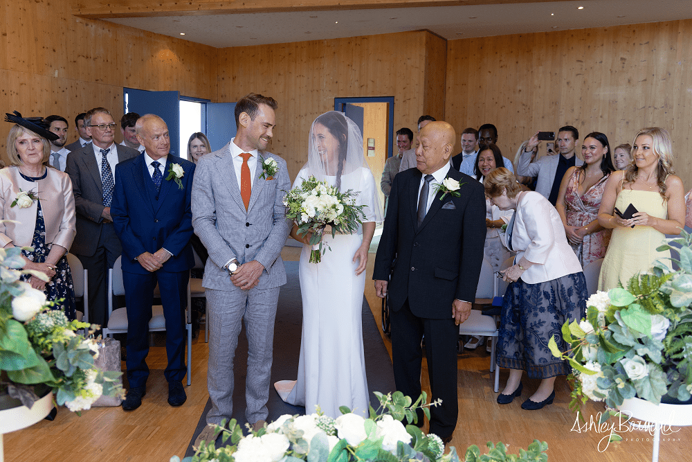 Bride and Groom stood in front of a group of people.